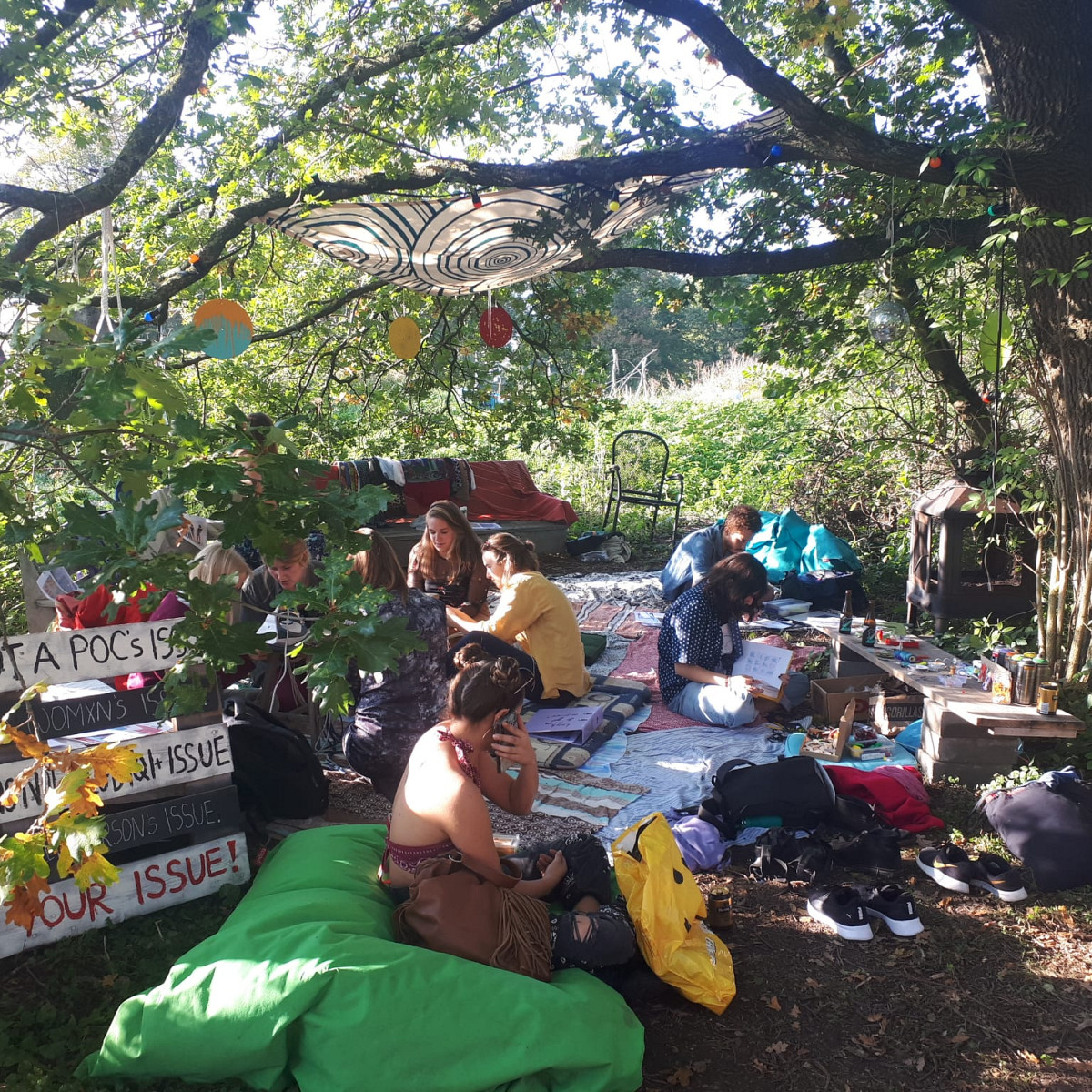 Grounded studenten ontspannen op kussens op de grond bij een festival